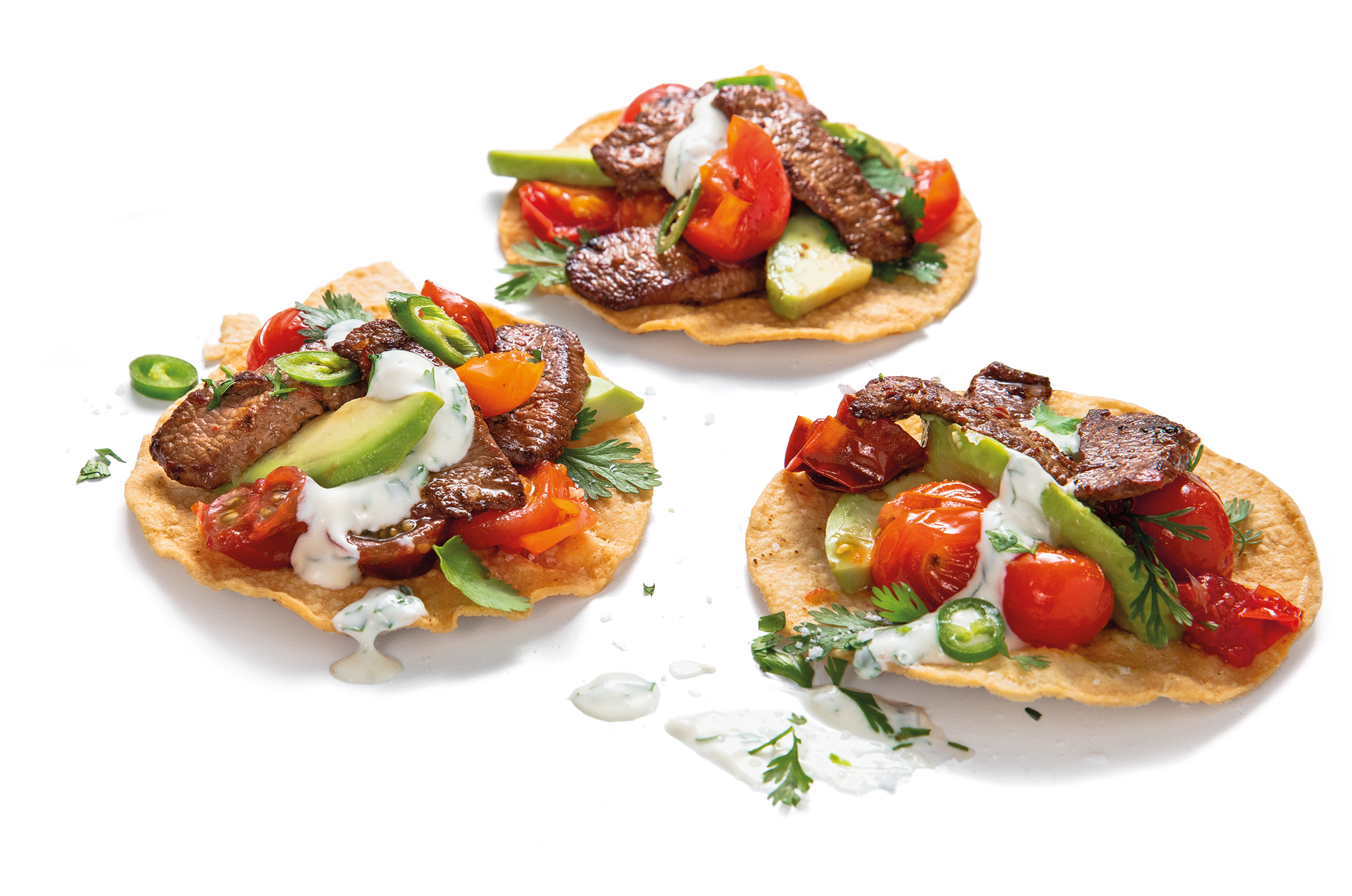Lamb Stir-Fry Tostadas with Coriander and Lime Dressing on plain background