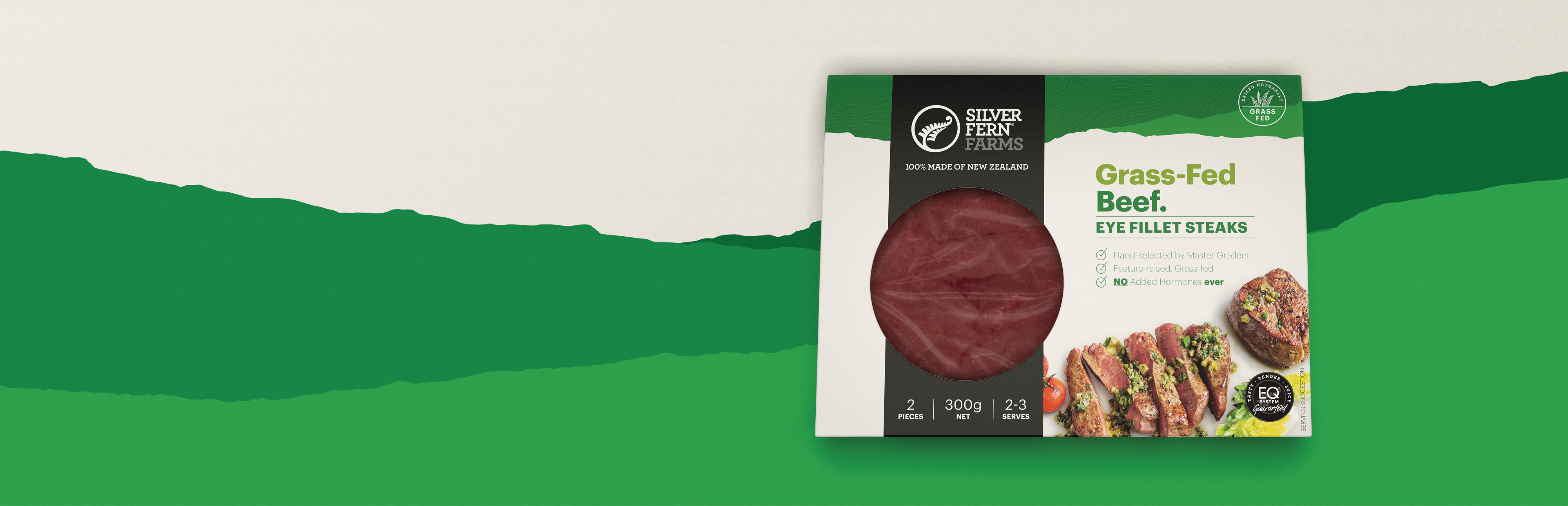 grass-fed beef eye fillet steaks packaging on an illustrated background of green hills