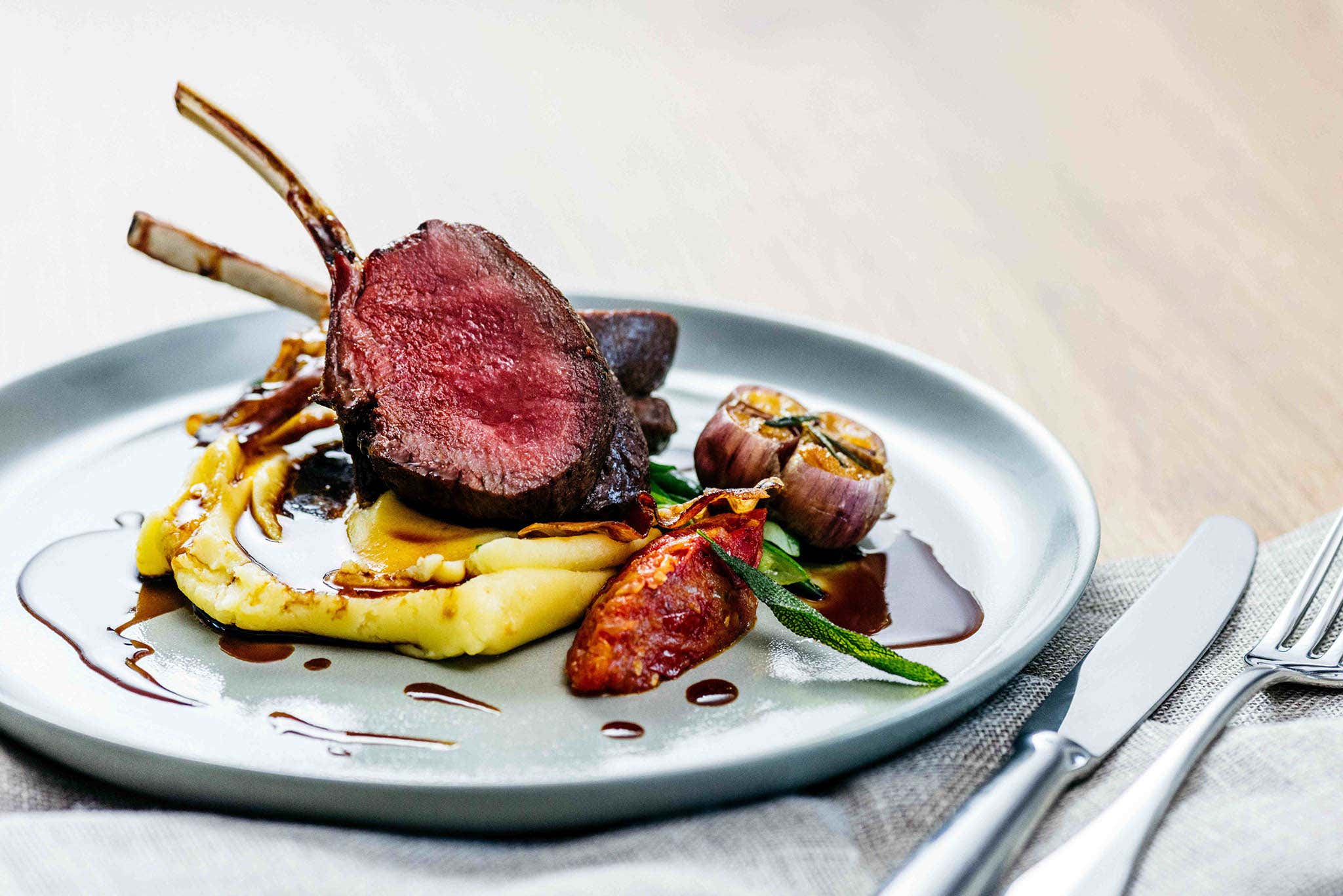 A plate of venison with mashed potato on a table