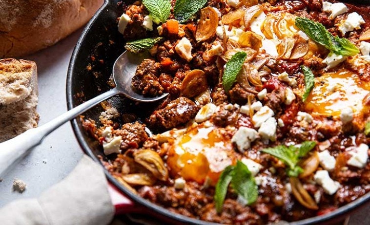 Venison Shakshuka  on a cast iron skillet with spoon