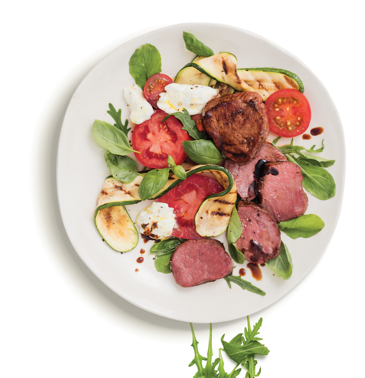 Balsamic Glazed Venison Medallions with Caprese Salad on a white plate