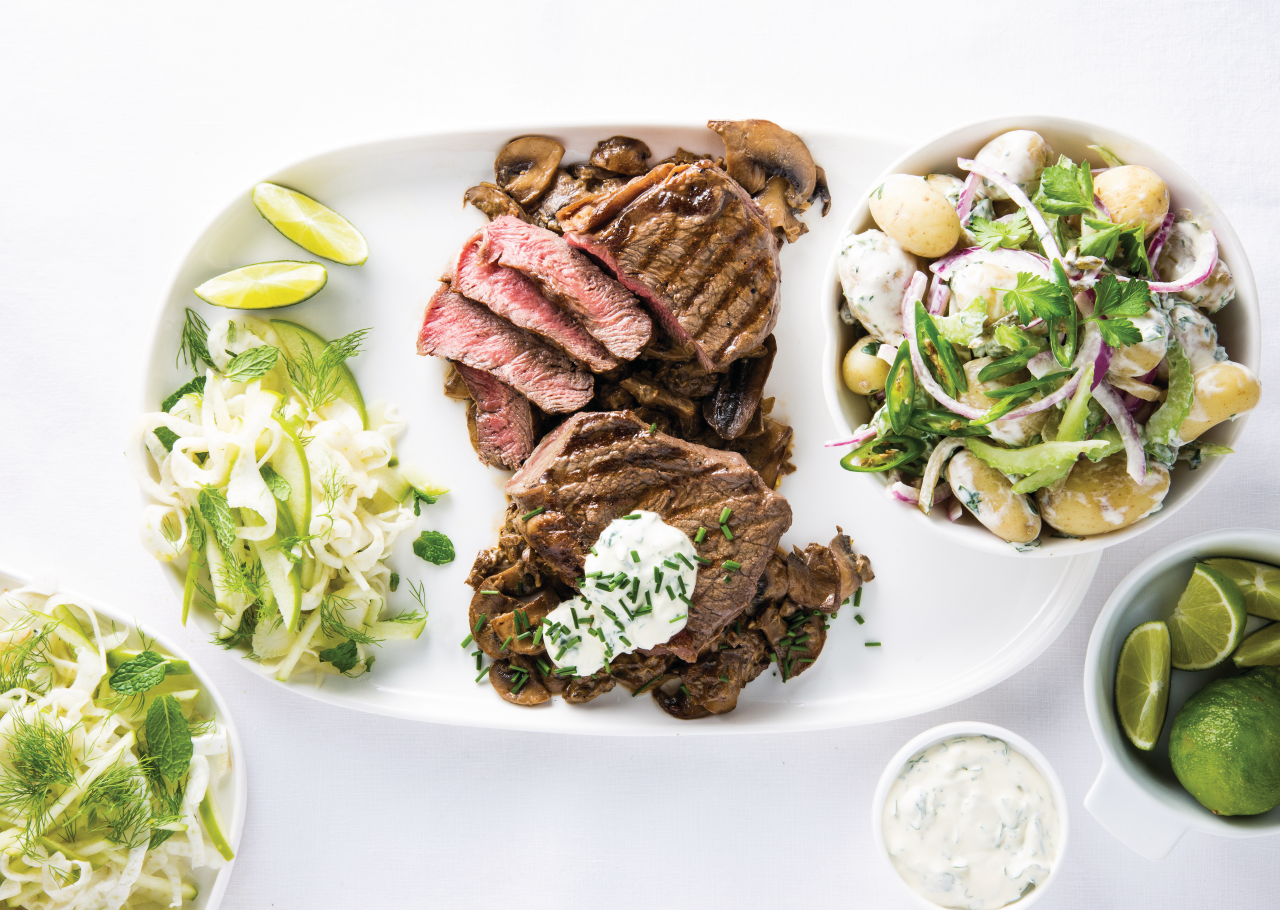 Beef Medallion with Mushroom Sauce on a white plate next to a potato salad