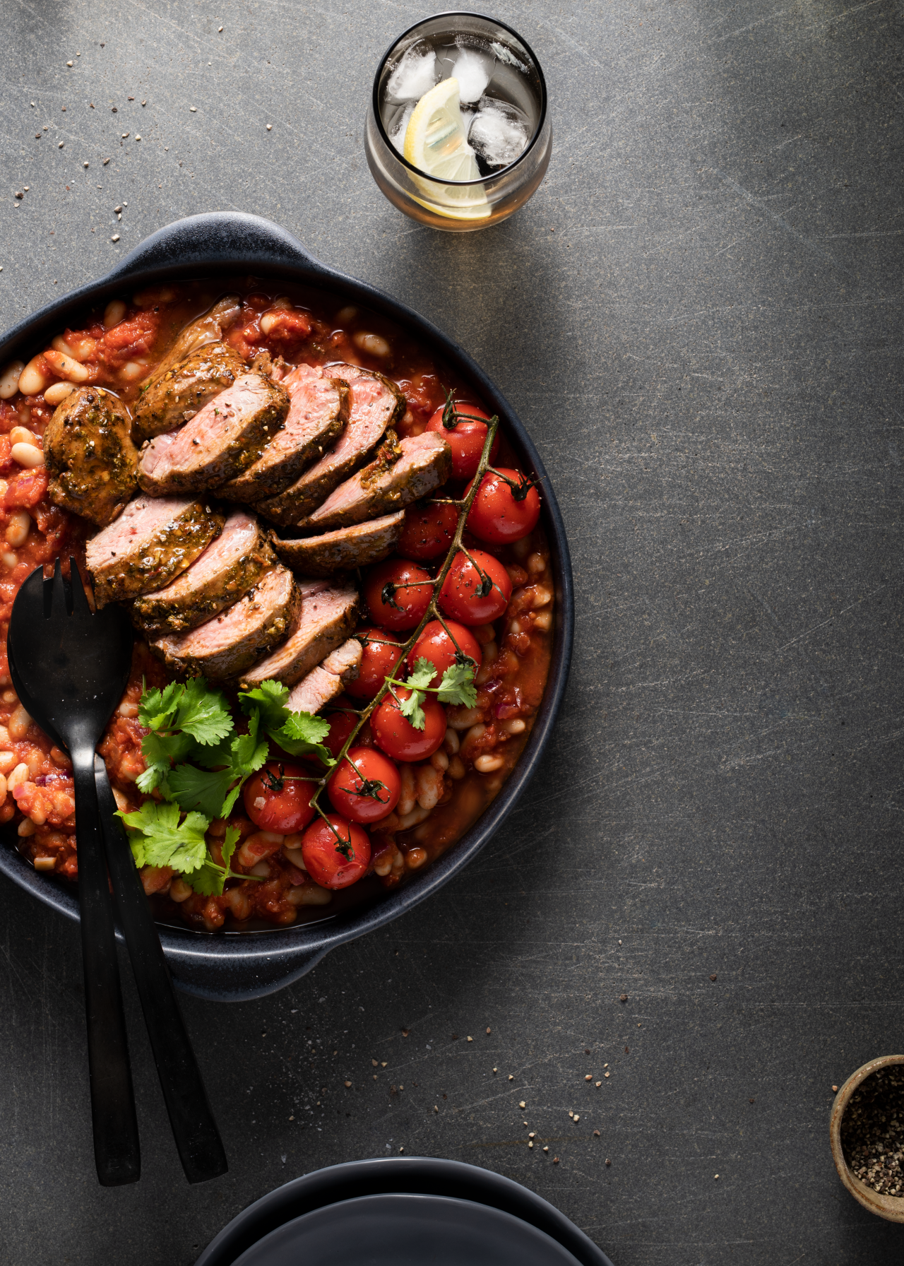 Lamb Rumps with Chermoula in a pot with black serving spoons on the side