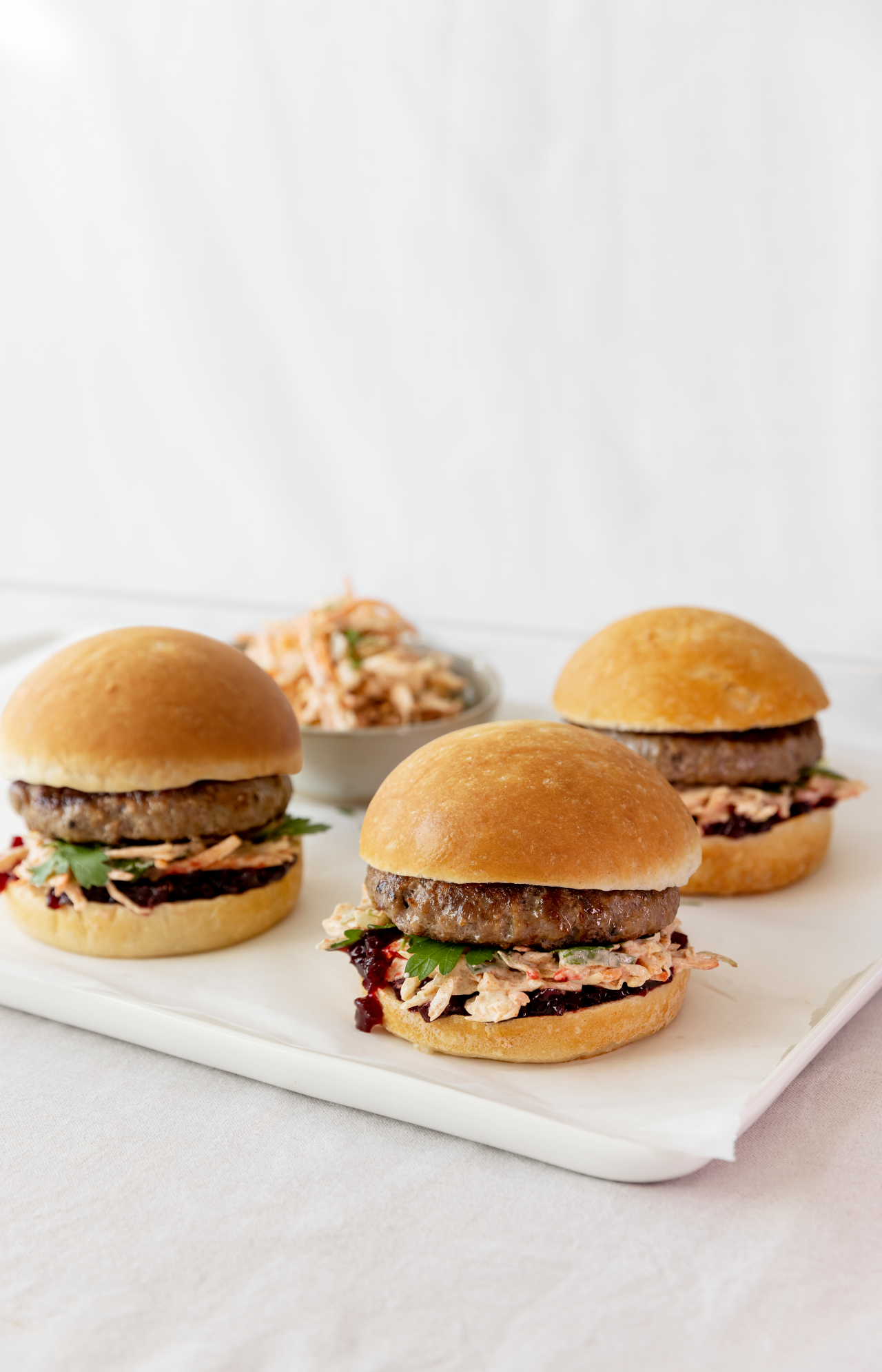 Venison & Beef Burgers with Beetroot Chutney & Slaw on a chopping board