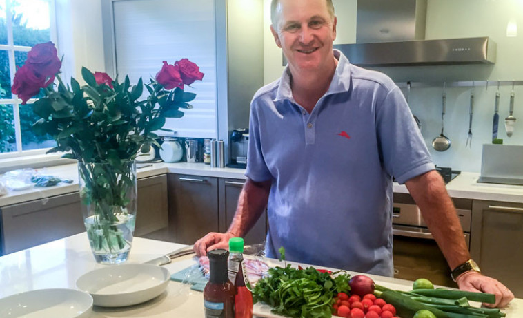 John Key standing in his kitchen