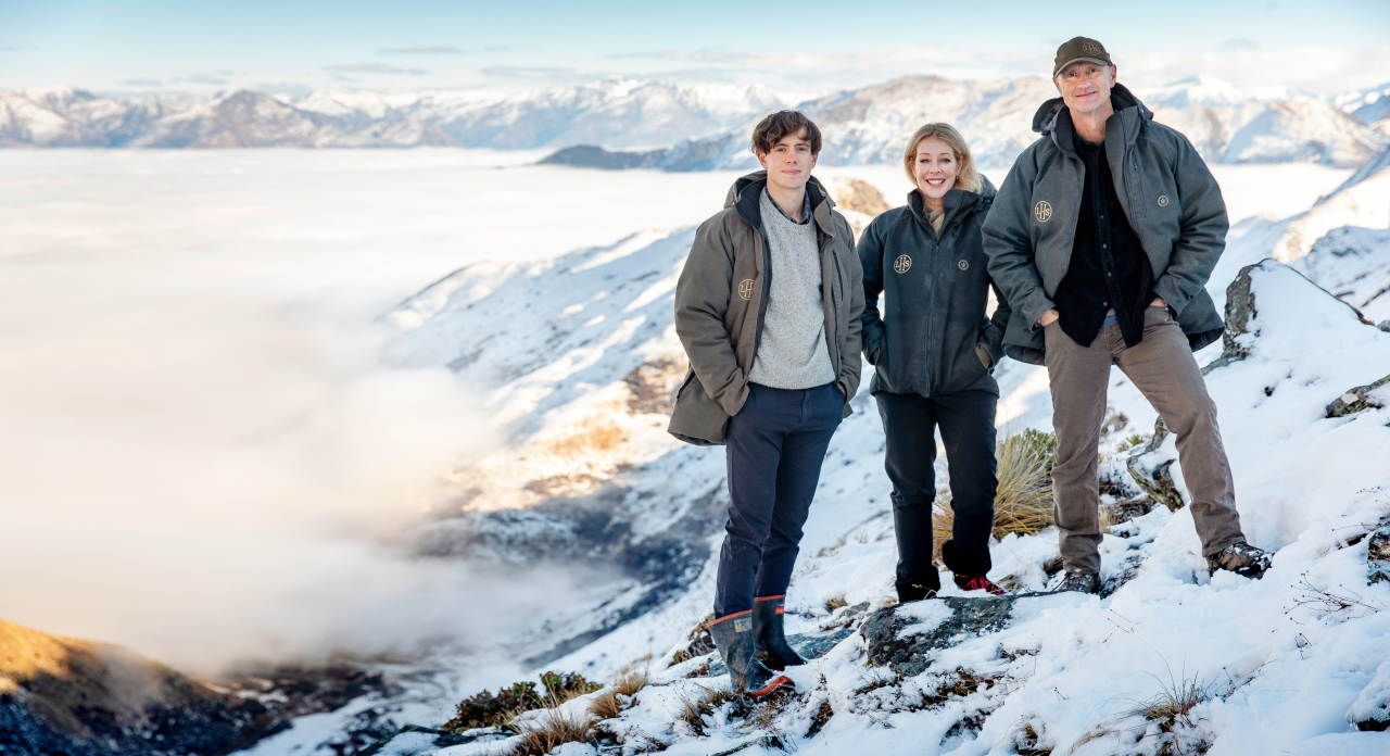 Farmer Geoff and Justine Ross of Lake Hawea Station standing on a snowy hill with clouds around them