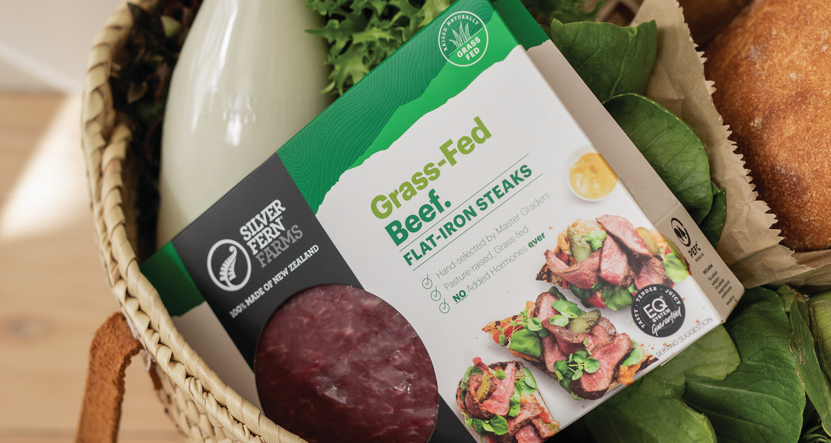 A food hamper in a wicker basket with Silver Fern Farms Beef packet sticking out the top