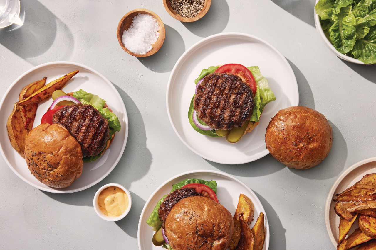 Three Pure Burgers Beef Short Rib with fries on white plates