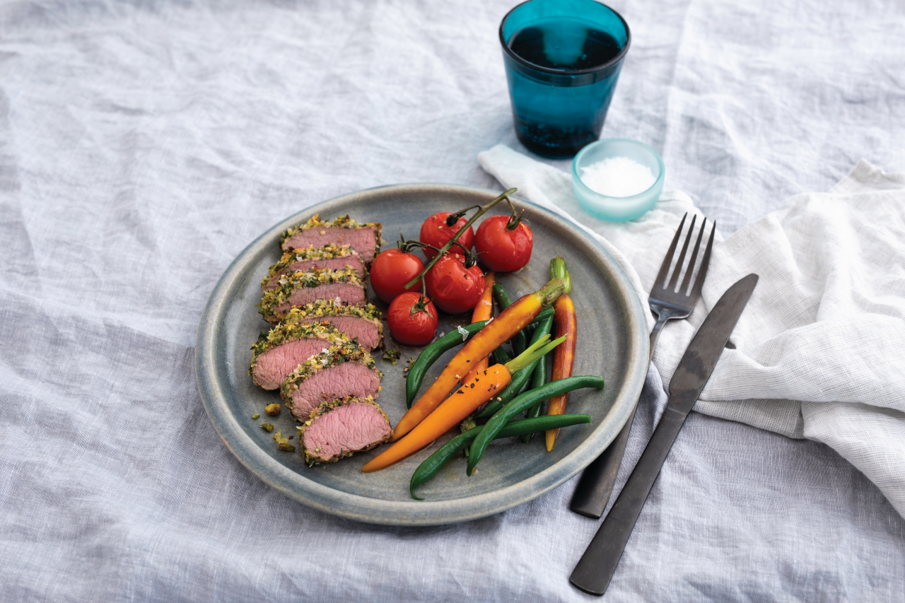 Lamb Loin Fillets with Pistachio, Mint and Parsley Crust on a grey plate