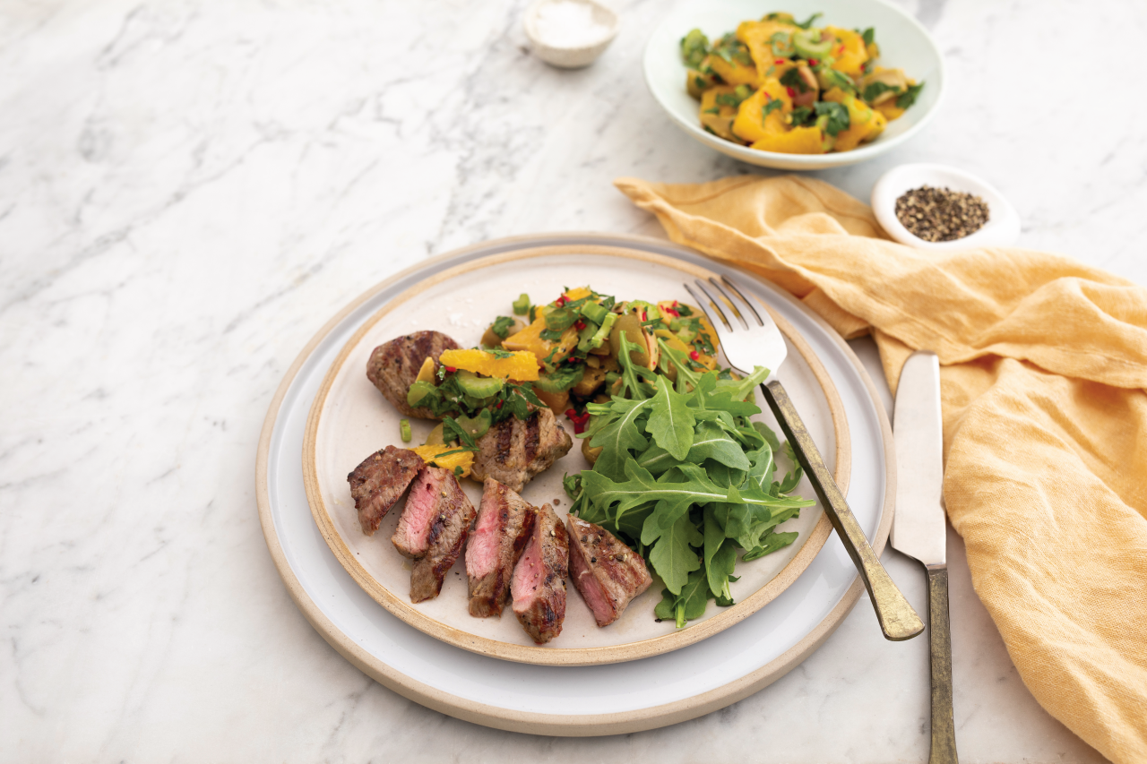 Seared Lamb Medallions with Fresh Orange, Green Olive and Herb Salsa on a white plate