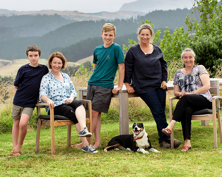 Farmer Story: Anna Blair and Family sitting around table outside with dog on grass